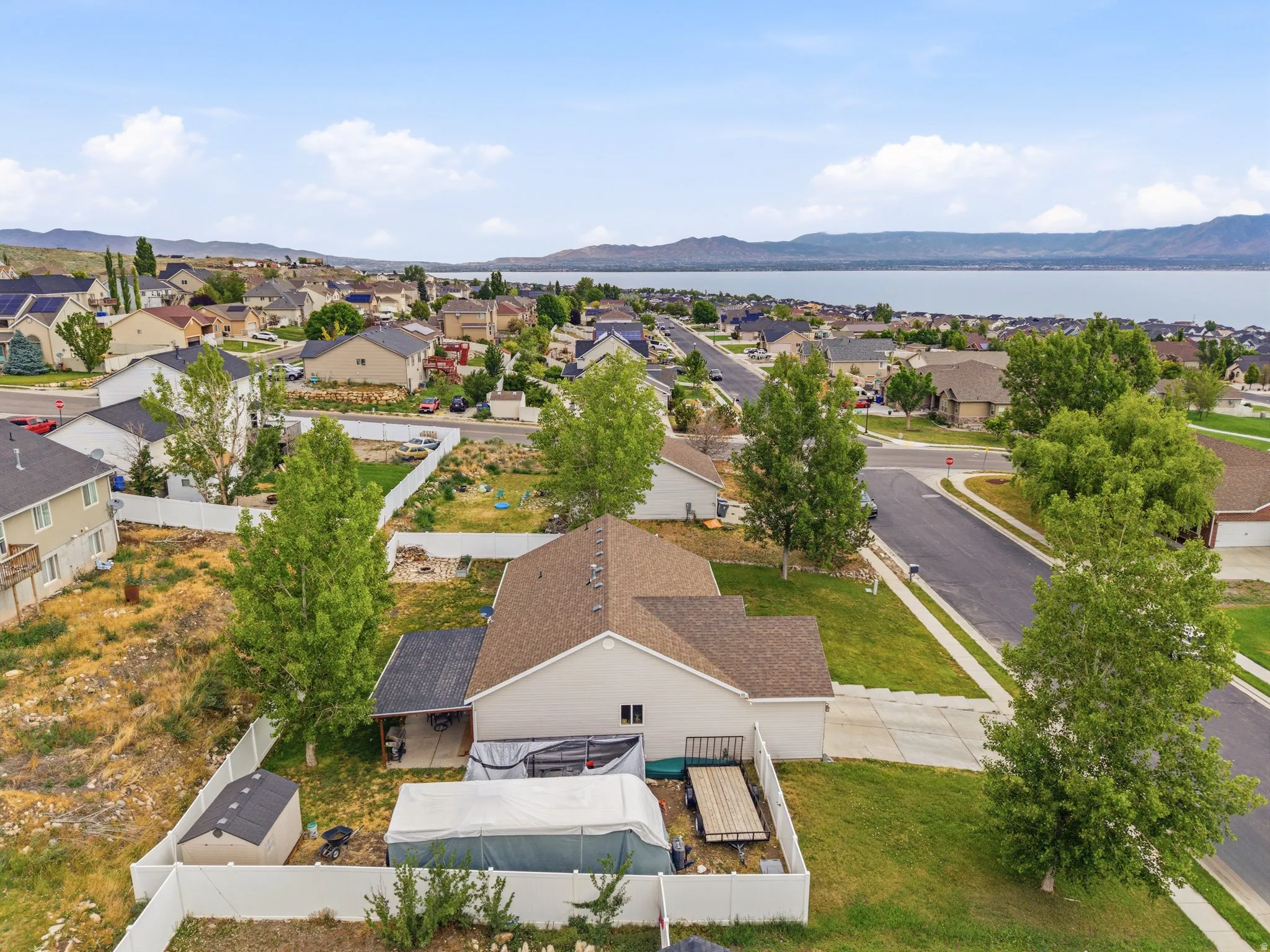 Single-story residence featuring a neutral exterior, a private fenced yard, a covered patio area, and a detached storage shed