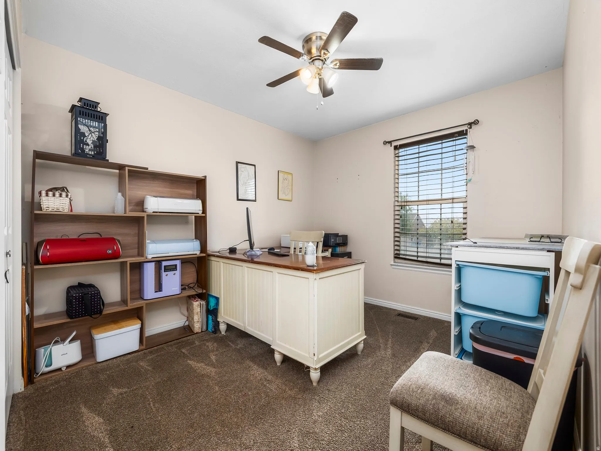 Room featuring neutral wall tones, textured carpeting, and a ceiling fan with integrated lighting