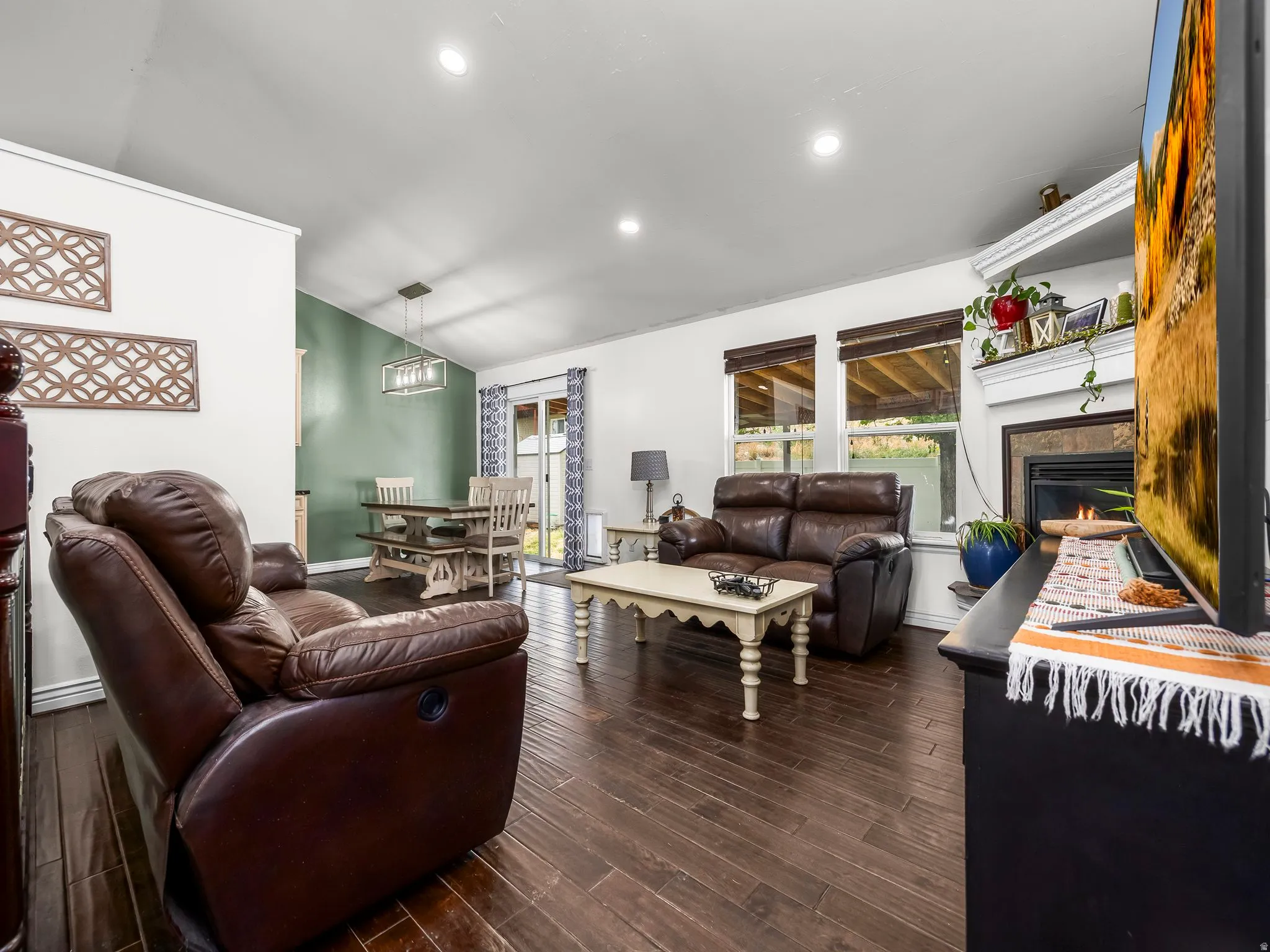 Living area featuring wood-finish flooring, recessed lighting, and a fireplace with a white mantel