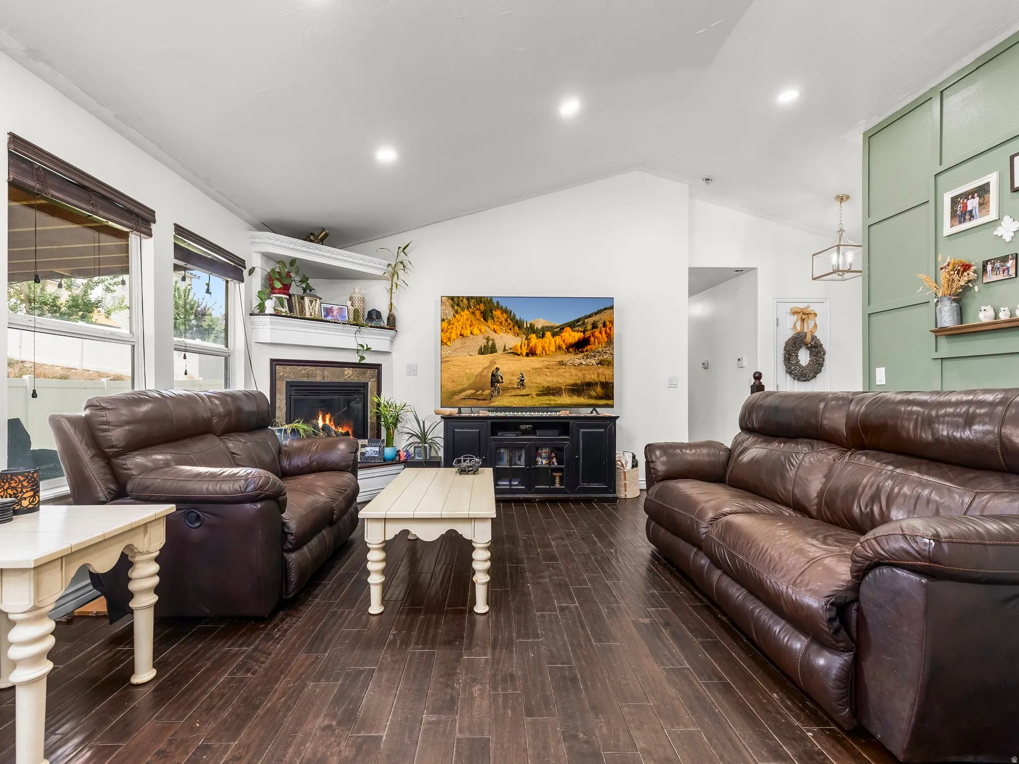 Living area featuring wood-finish flooring, vaulted ceilings, and recessed lighting