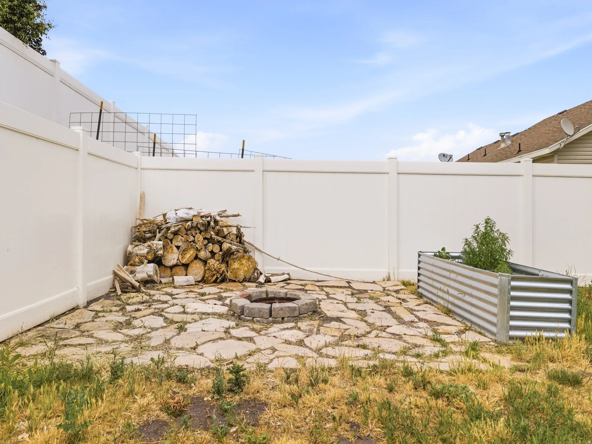 Outdoor patio area featuring flagstone-style paving and a built-in stone fire pit