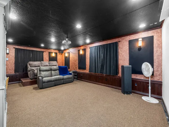 Dedicated media room featuring recessed lighting, a dark ceiling, textured walls, and a projector