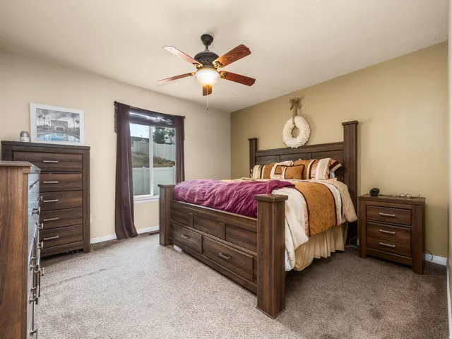 Primary Bedroom with neutral tone walls complement the textured carpeting