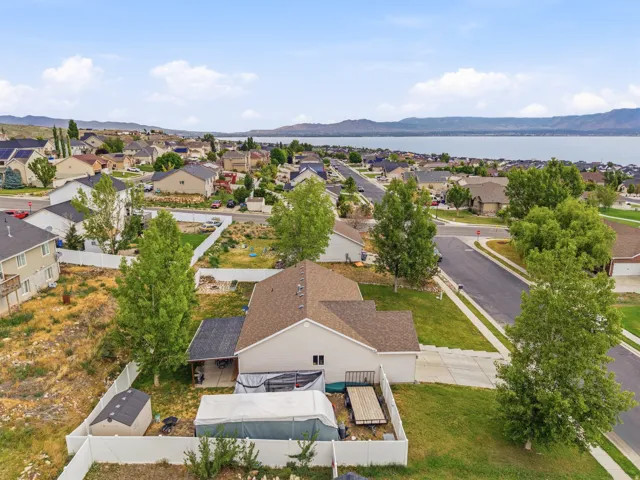Single-story residence featuring a neutral exterior, a private fenced yard, a covered patio area, and a detached storage shed