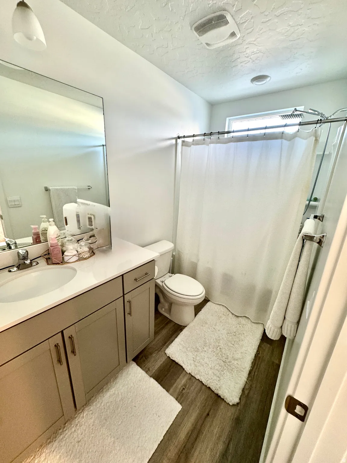 Bathroom featuring a single vanity with a white countertop and gray cabinetry