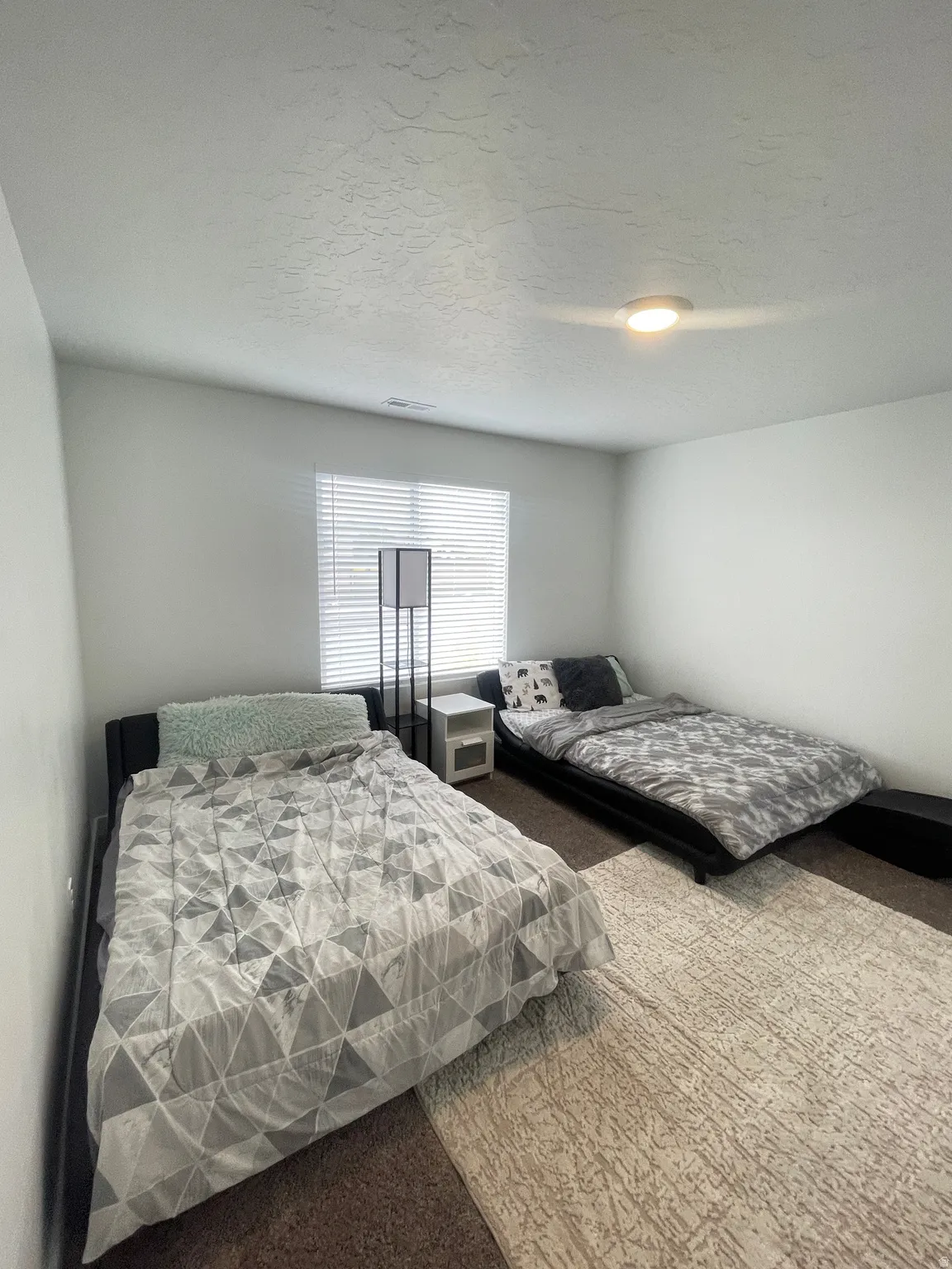 Room featuring light-colored walls and textured ceilings
