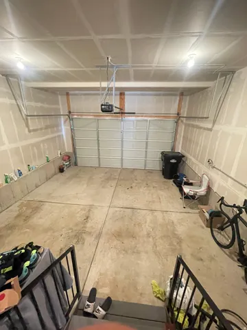 Spacious garage featuring concrete flooring and an automatic garage door opener