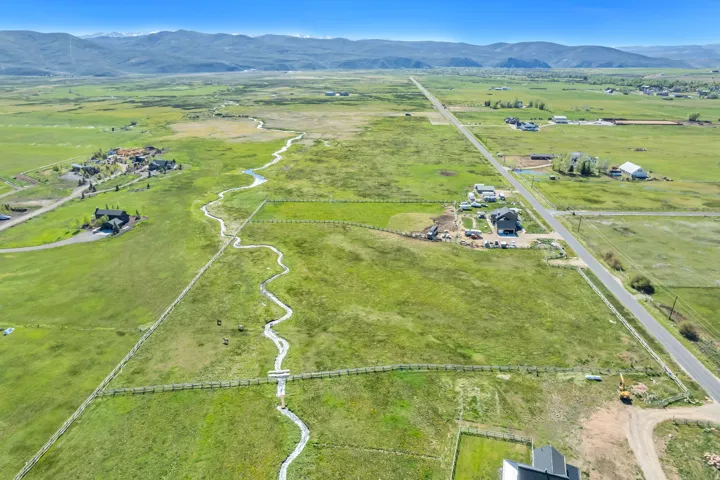 Expansive green landscape with distant mountains under a clear sky
