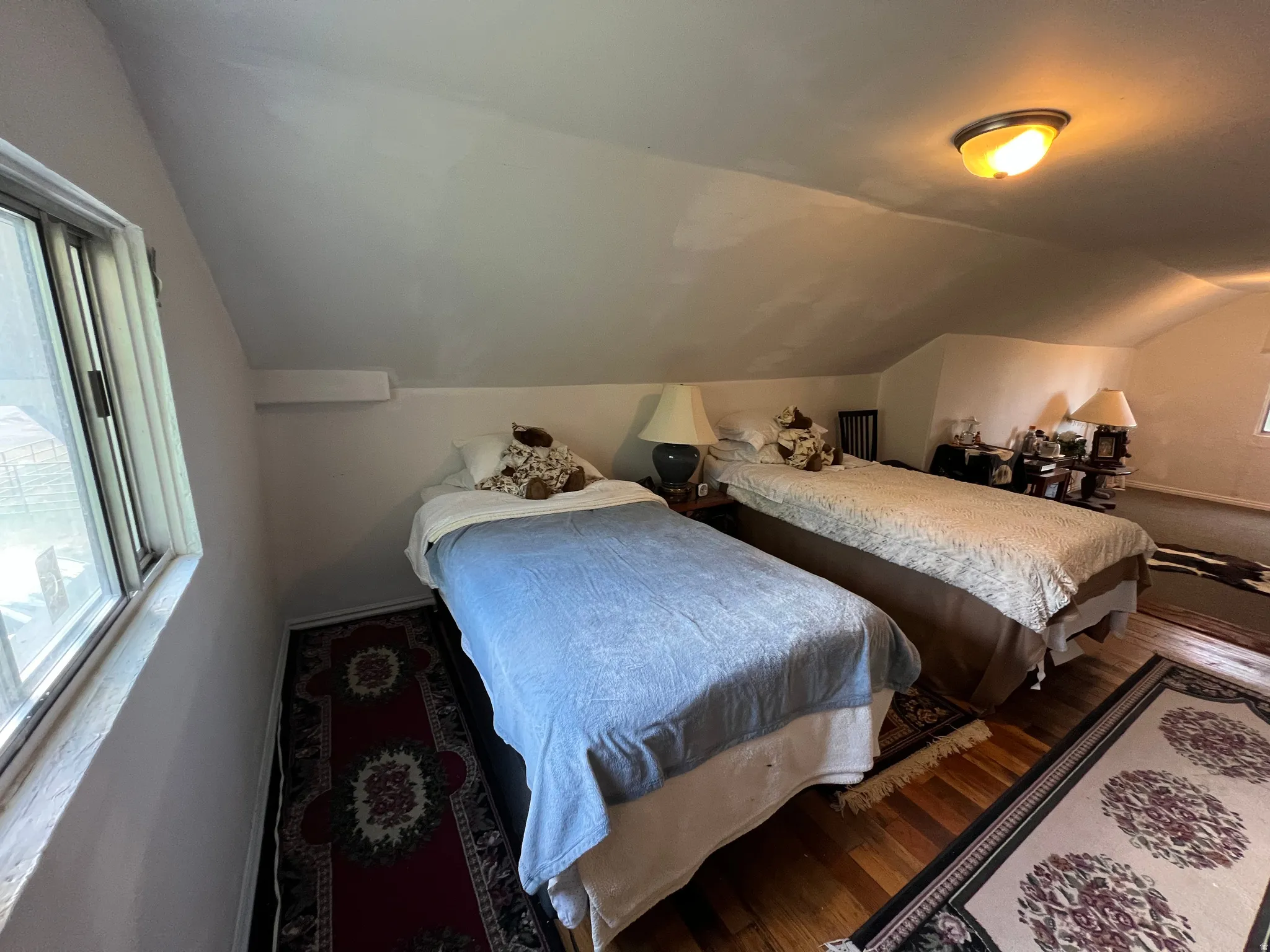 Attic space with sloped ceilings and a single-pane window