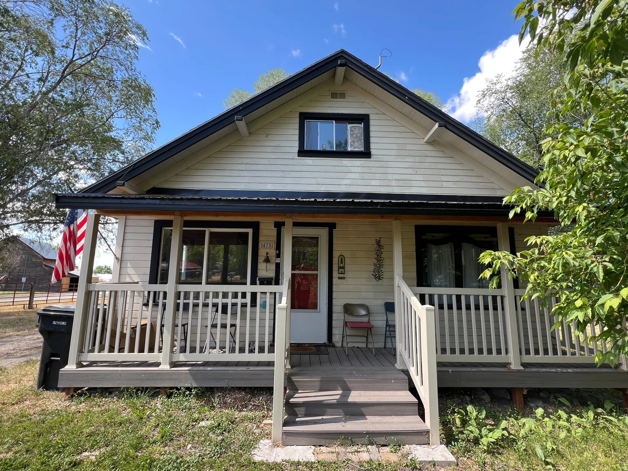 Exterior featuring horizontal siding, a covered porch with railings, and a prominent gable roof