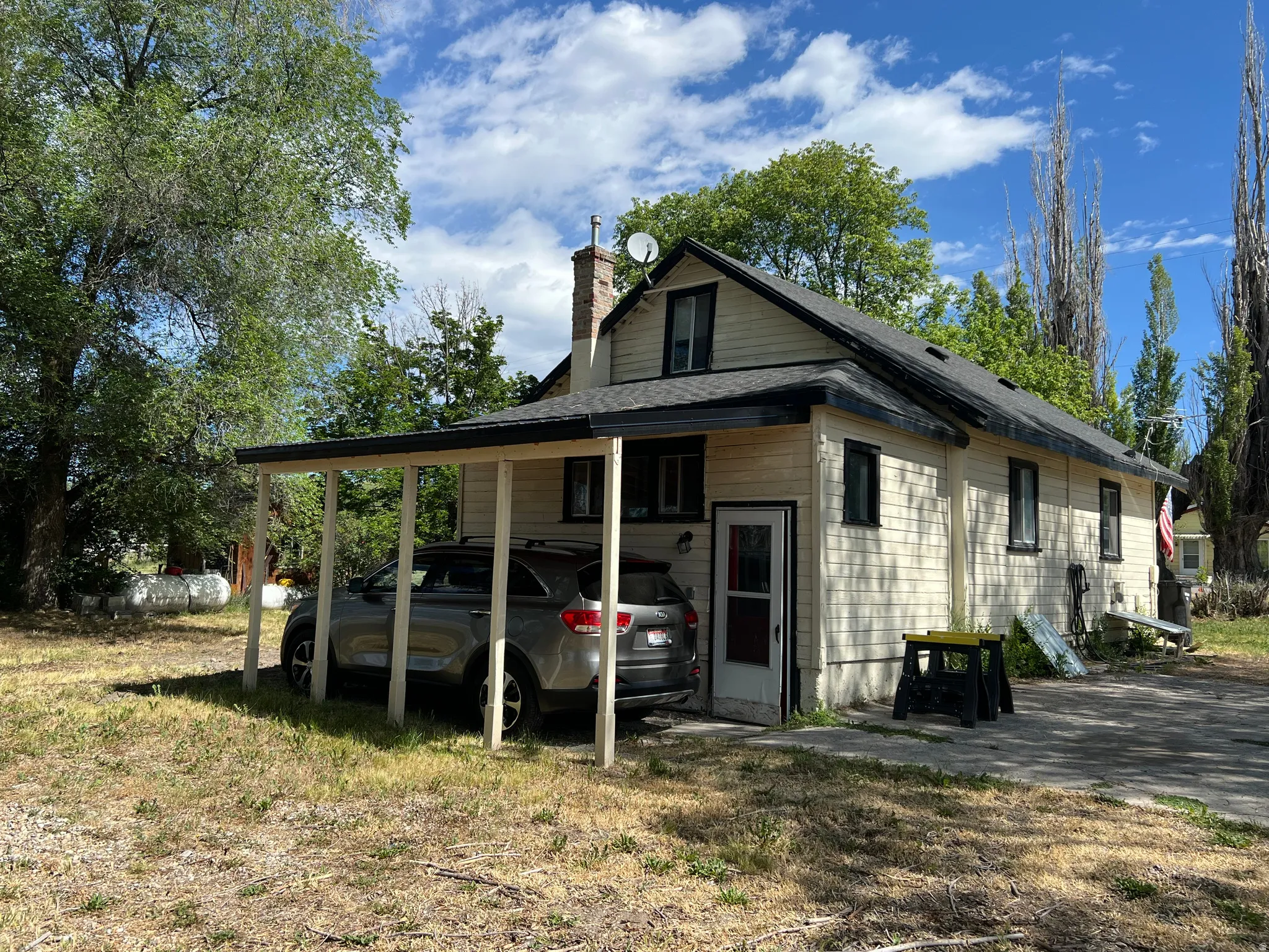 Exterior featuring light-colored siding, a dark shingled roof, and black window trim