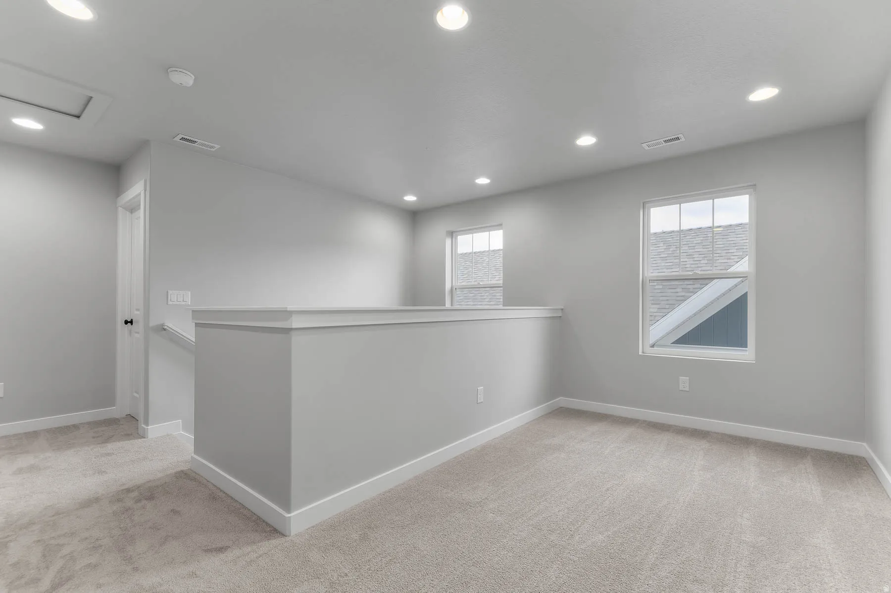 Open loft area featuring neutral carpeting and recessed lighting