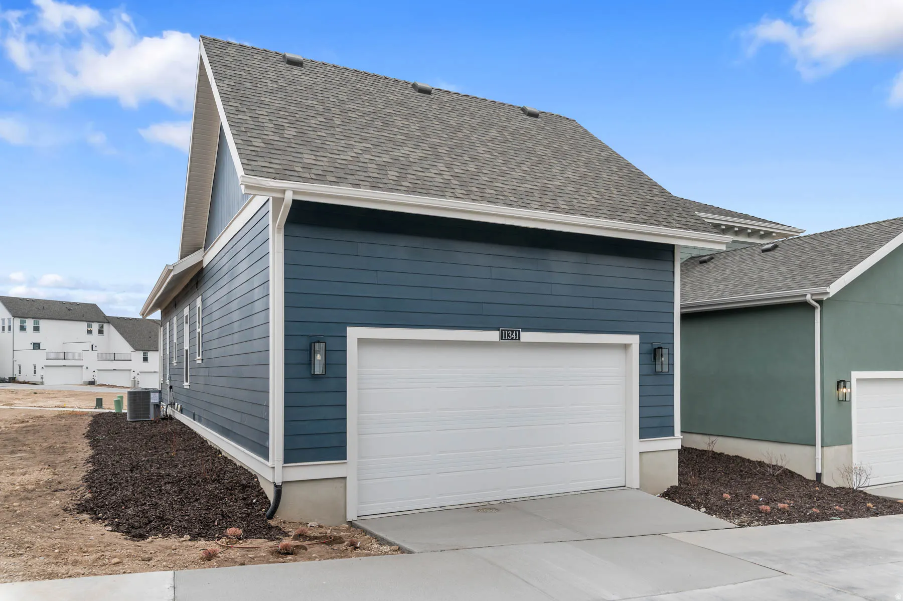 Exterior featuring blue horizontal siding, a white garage door, and a gray shingle roof