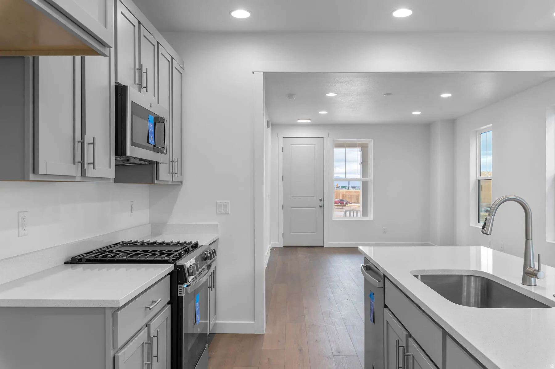 Contemporary kitchen featuring light gray cabinetry, stainless steel appliances, and sleek countertops