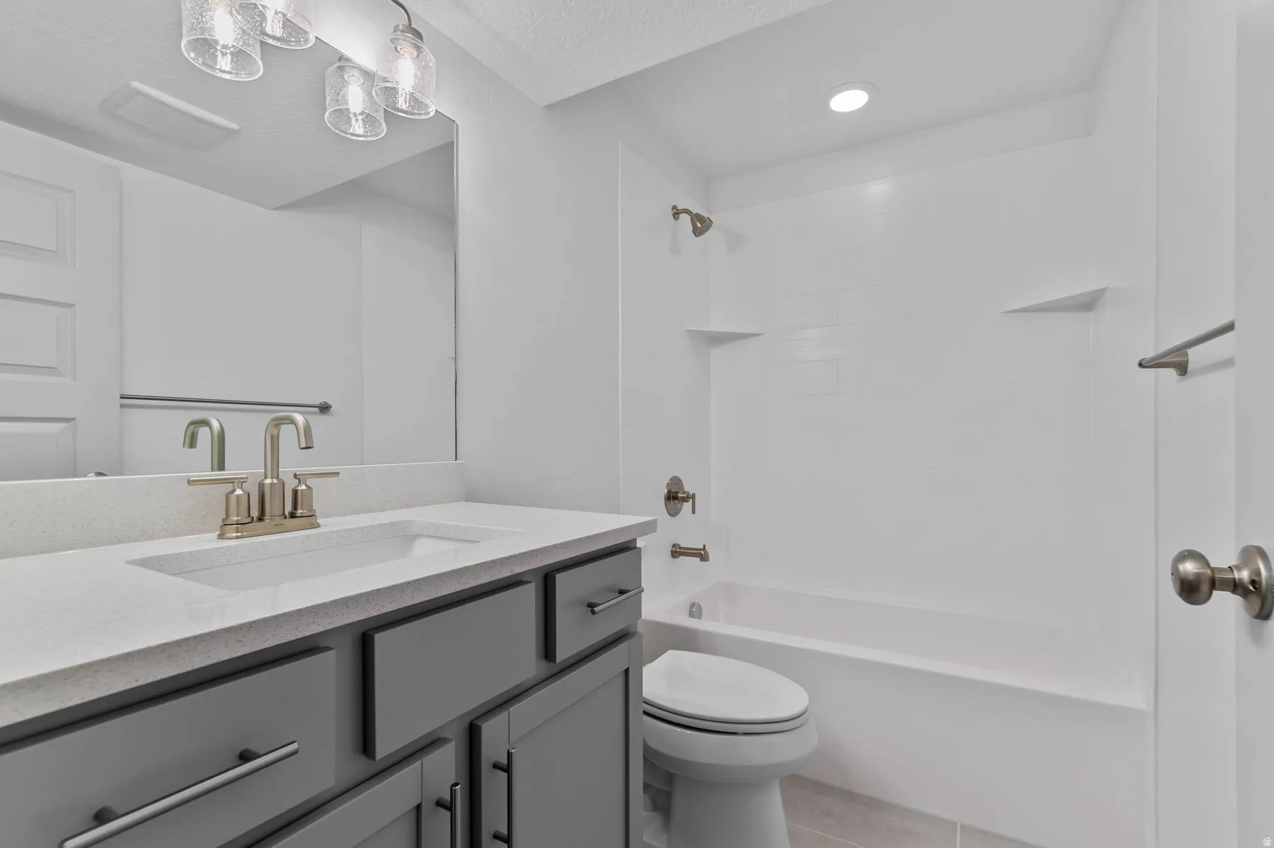 Bathroom featuring a gray vanity with a light-toned countertop, an integrated sink, and a brushed nickel faucet