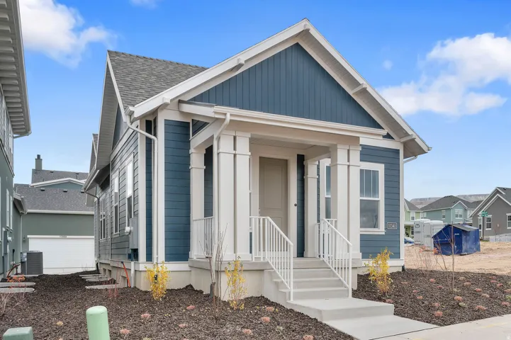 Contemporary residence featuring a striking blue siding exterior with white trim and a prominent front porch
