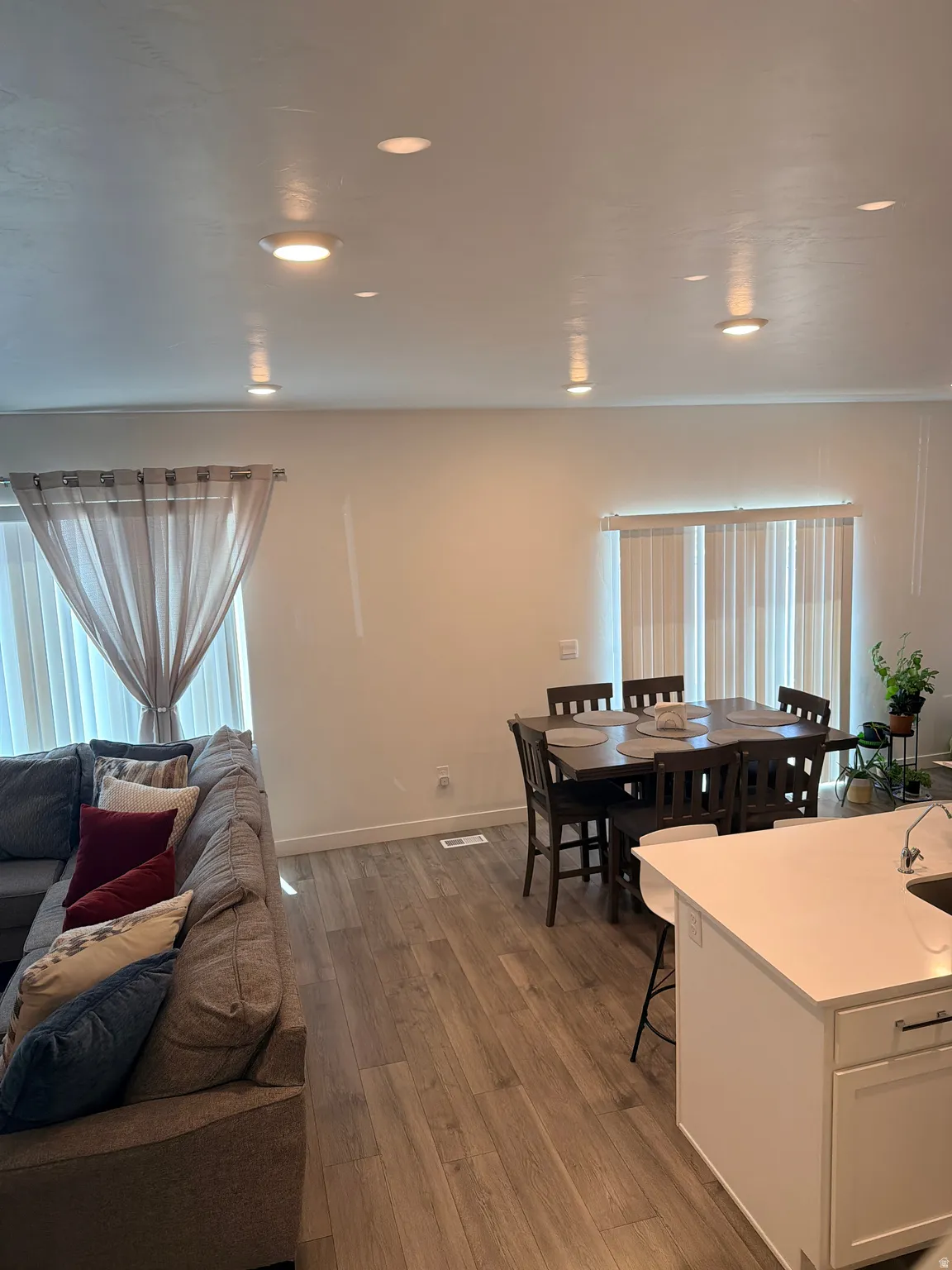 Open-concept living area featuring wood-finish flooring, recessed lighting, and white walls