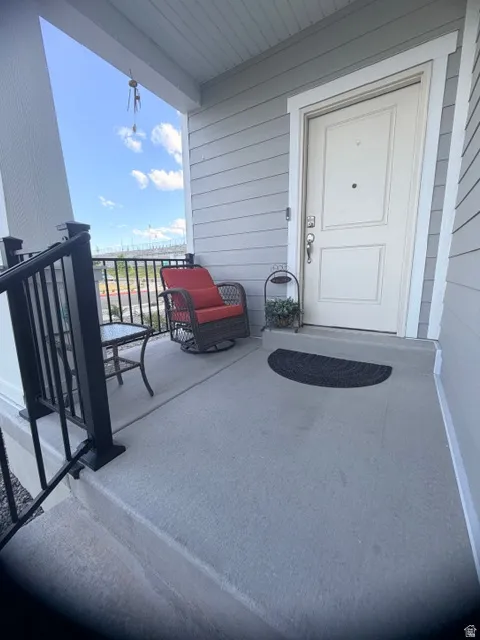 Inviting covered porch with concrete flooring and black metal railings