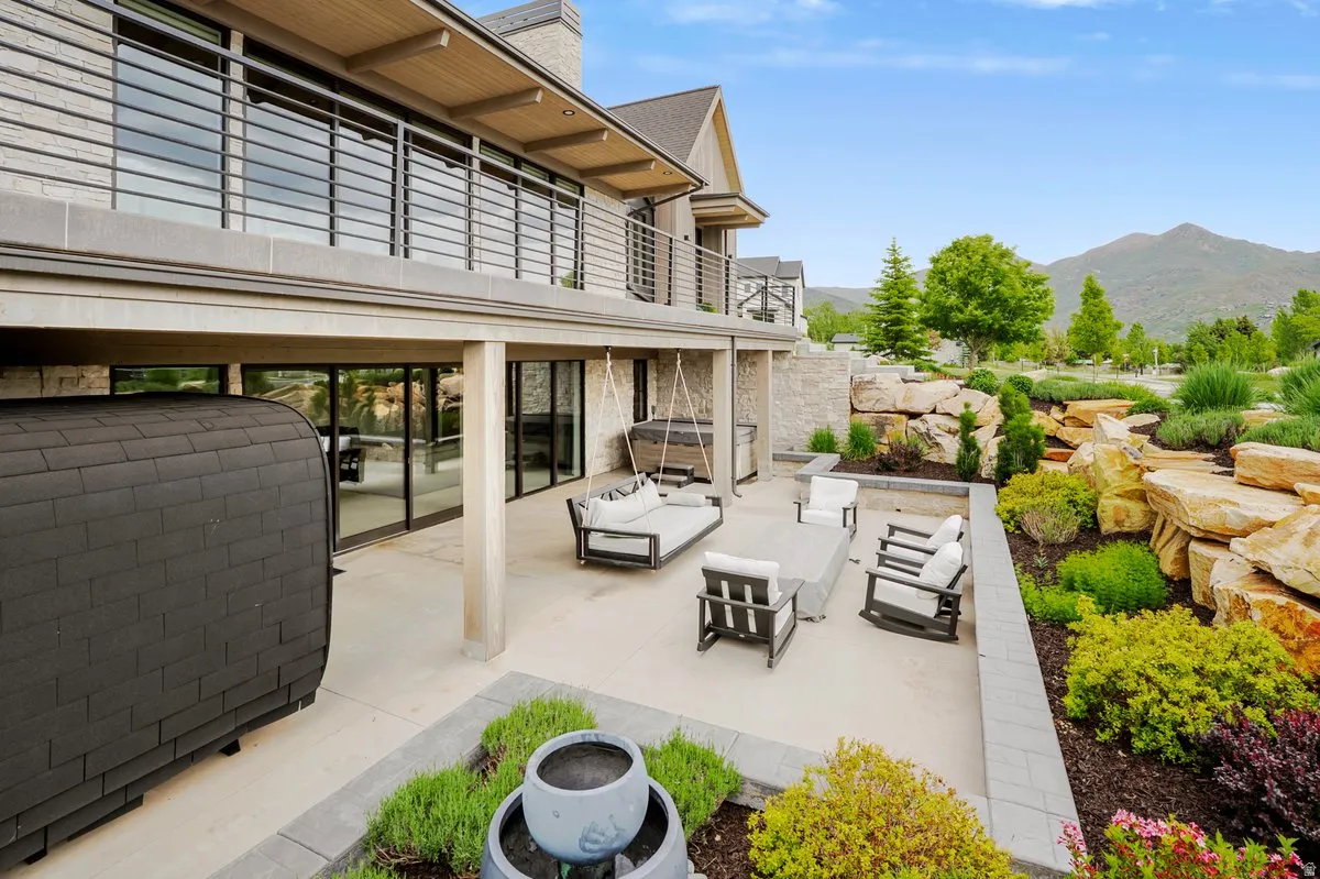 Expansive ground-level patio featuring a concrete surface, a built-in planter, and a swing bench