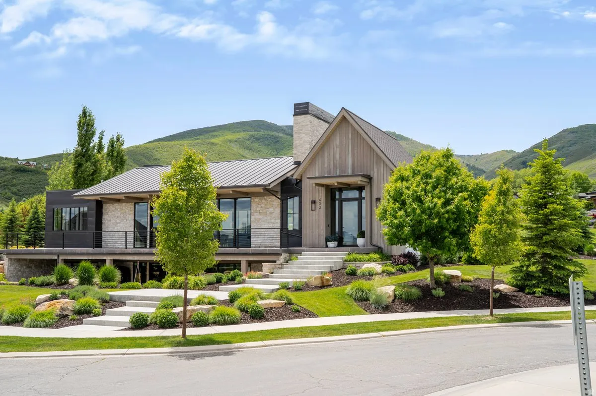 Modern architecture featuring a blend of stone, wood-finish siding, and dark paneling