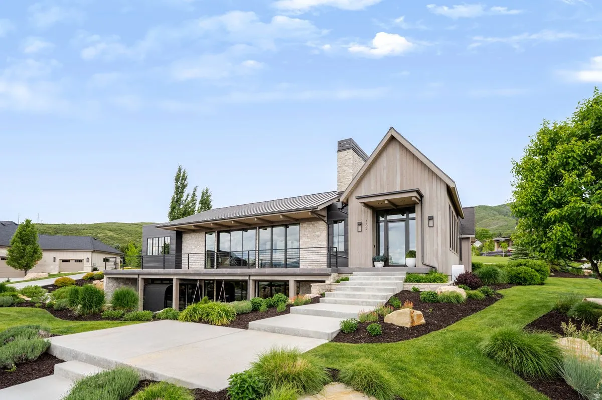 Modern exterior featuring wood-finish siding, stone accents, and a prominent gable entry