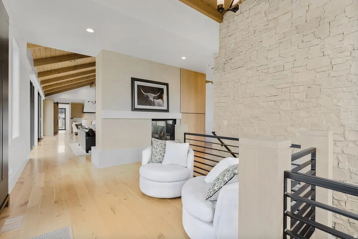 Vaulted ceilings with exposed wood beams complement light wood-finish flooring