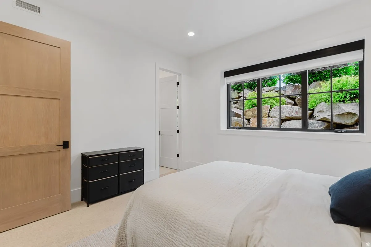 White interior walls with recessed lighting and neutral carpeting
