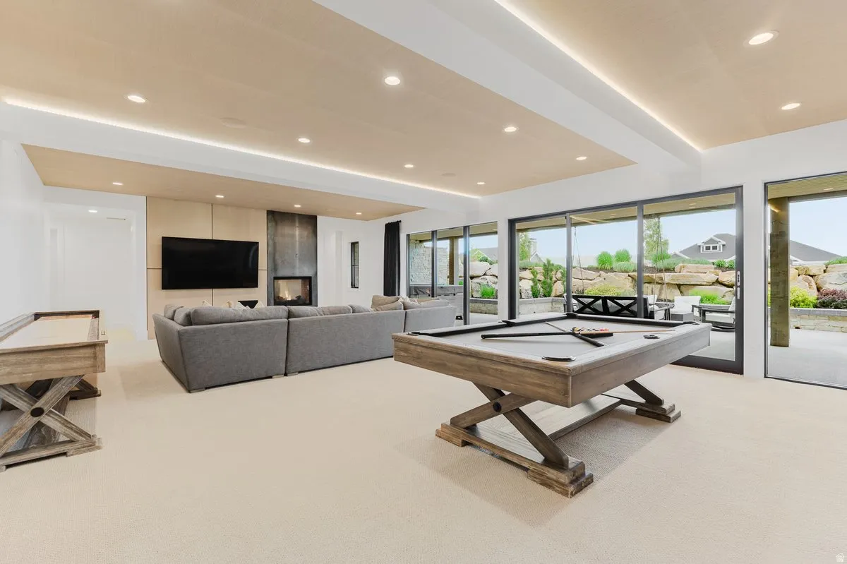 Expansive recreation room with recessed lighting and a wood-paneled ceiling feature