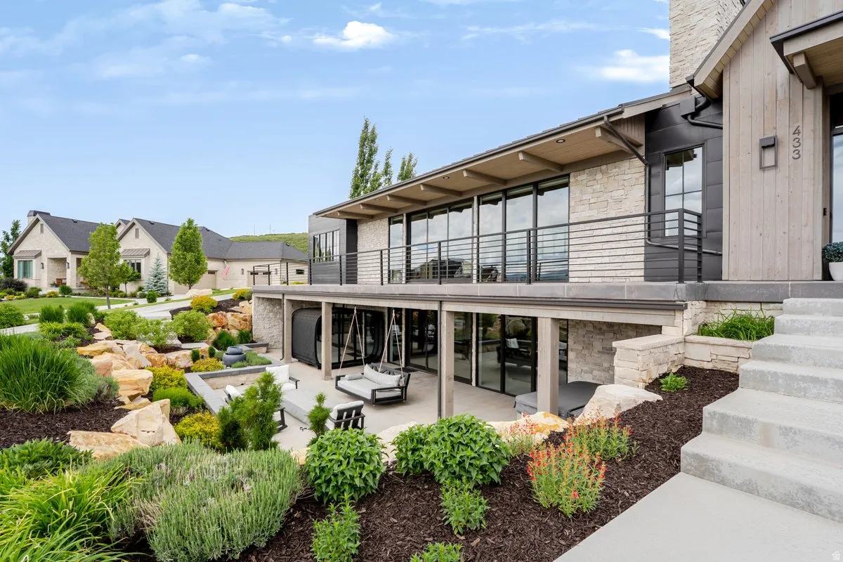 Stone and wood-clad exterior with a prominent balcony featuring horizontal bar railings
