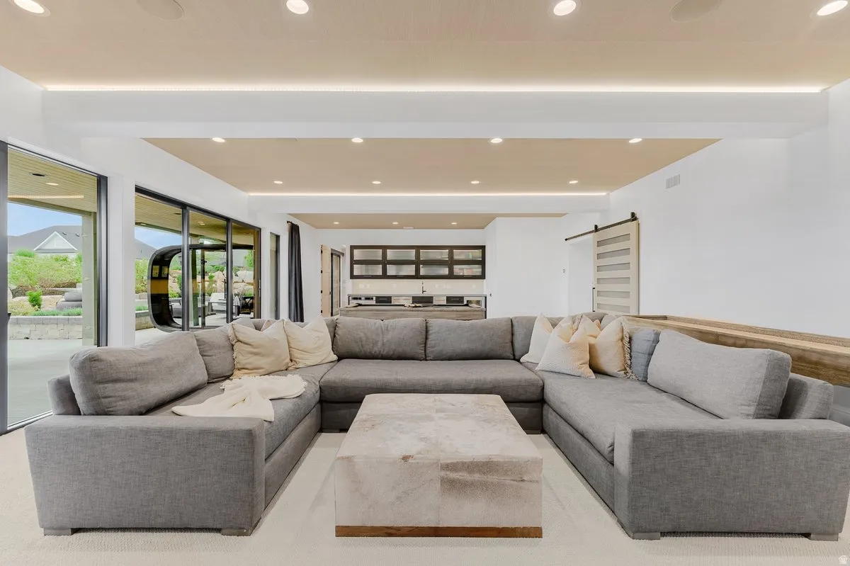 Open-concept living area featuring an architectural ceiling with recessed lighting and a perimeter light coves
