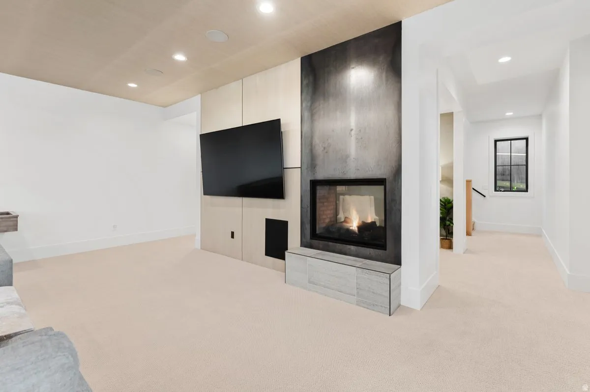 Open concept living area featuring a modern fireplace with a dark, textured surround