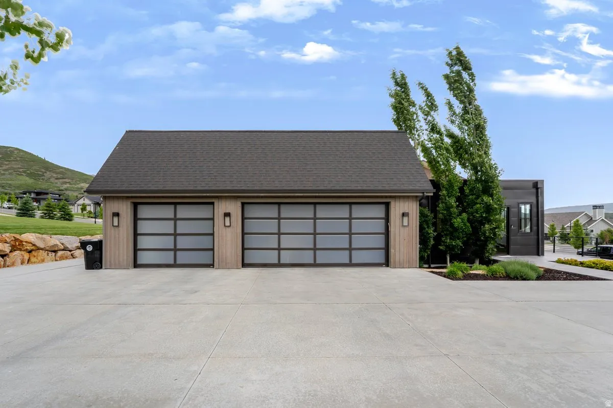 Contemporary two-car garage featuring frosted panel doors and integrated wall sconces