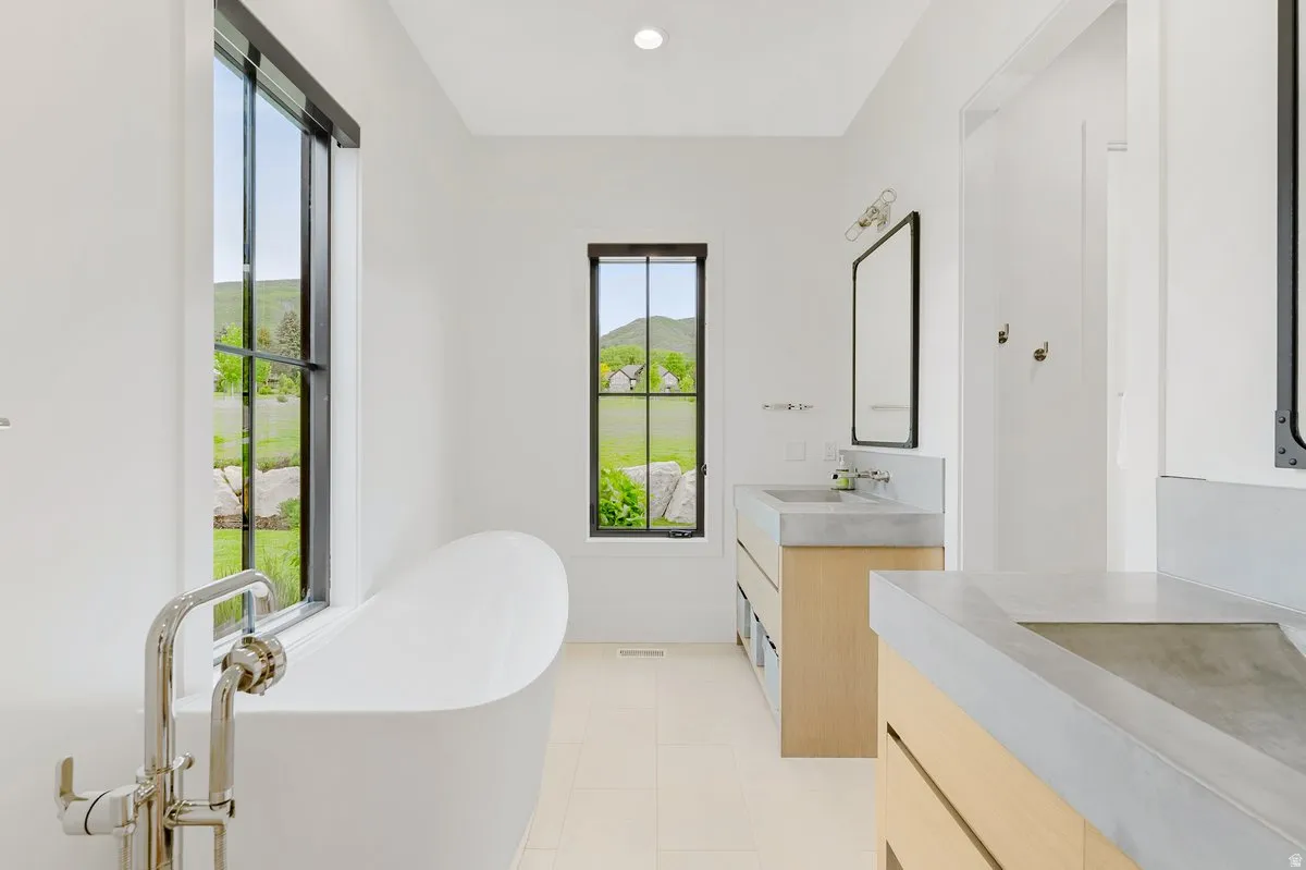 Freestanding soaking tub with polished chrome floor-mounted faucet