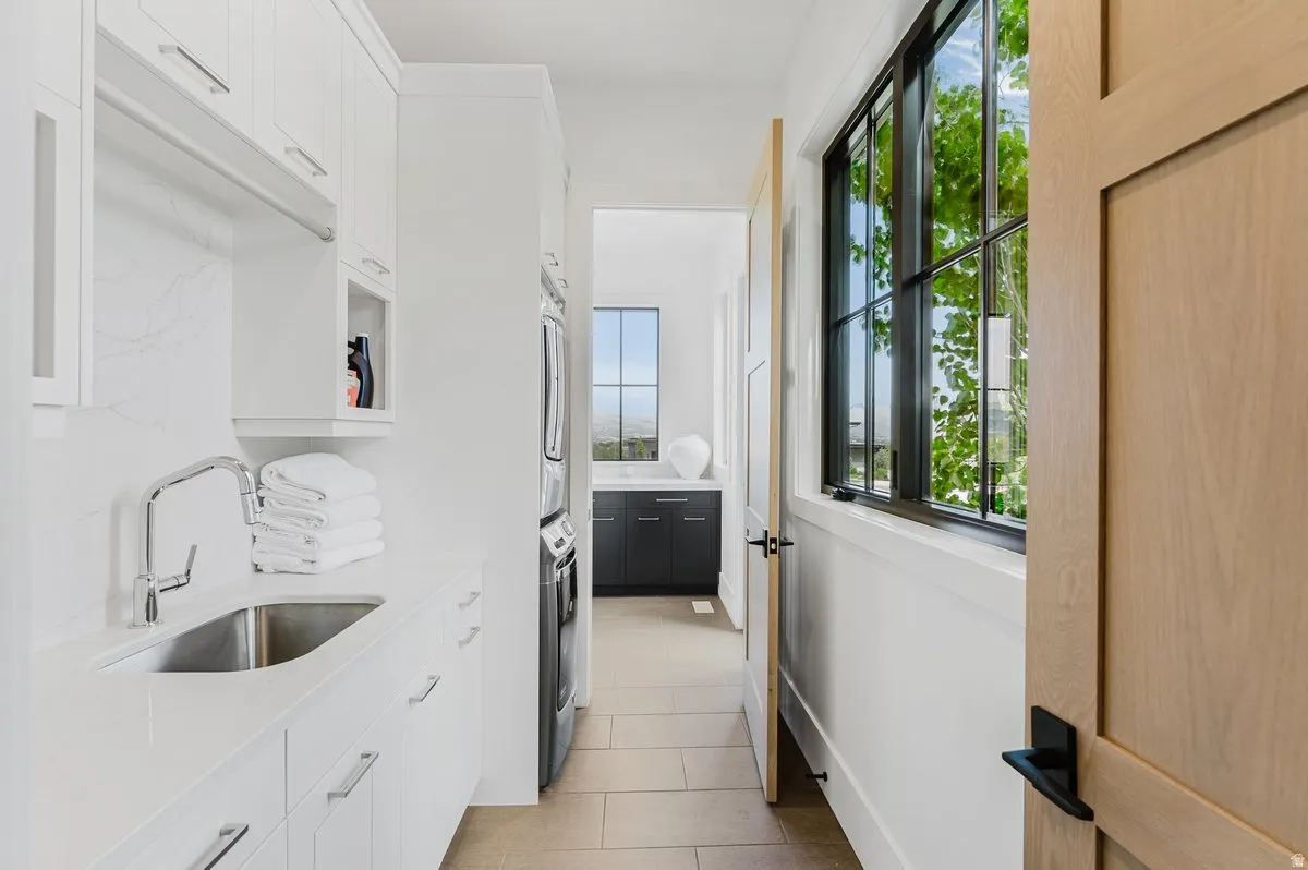Laundry area featuring white cabinetry, a single basin sink with a chrome faucet, and a light-colored countertop