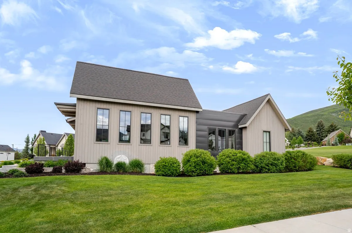 Contemporary architectural exterior featuring vertical light-toned siding and dark pitched roofing