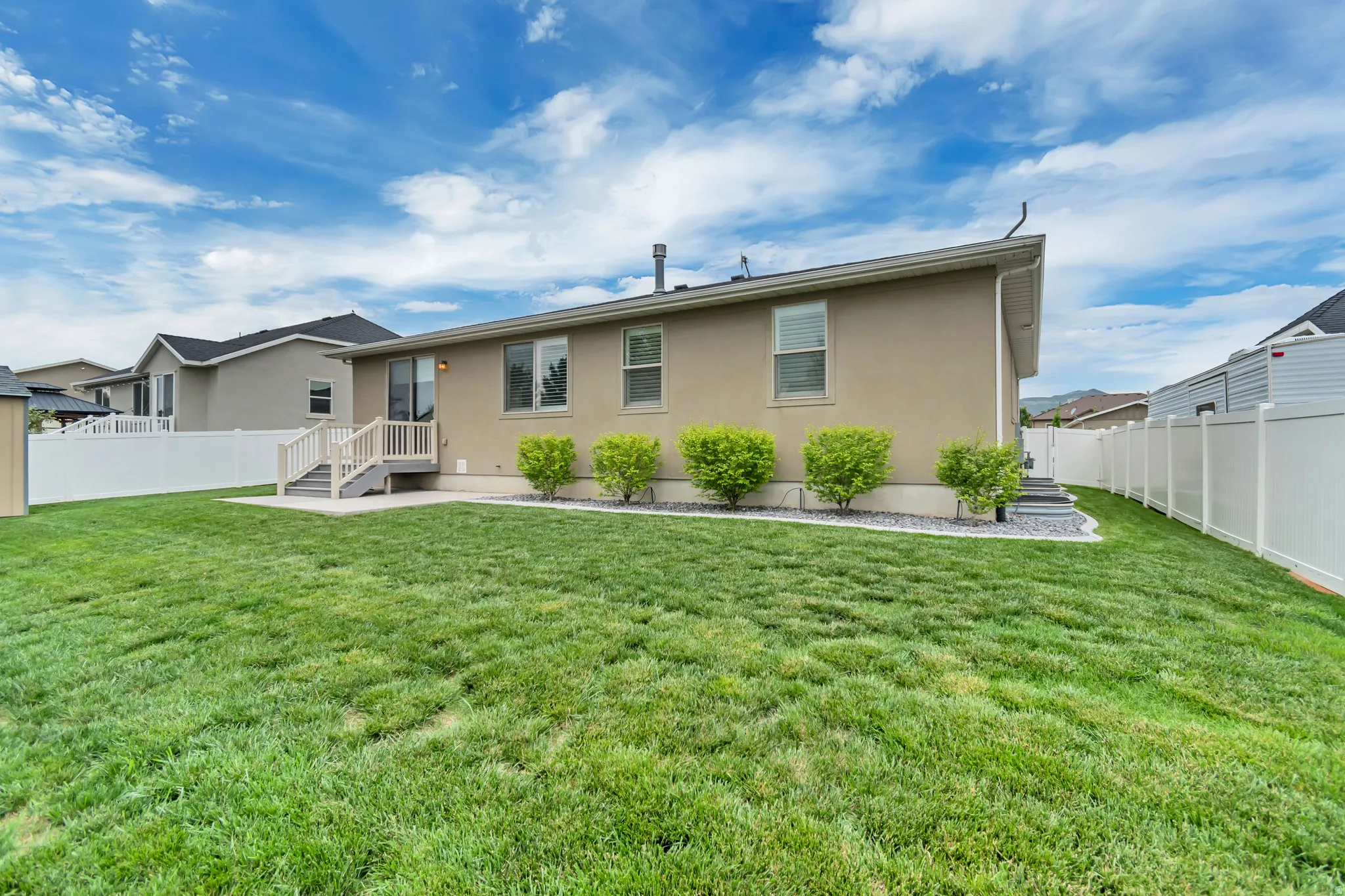 Expansive green lawn with a stucco exterior