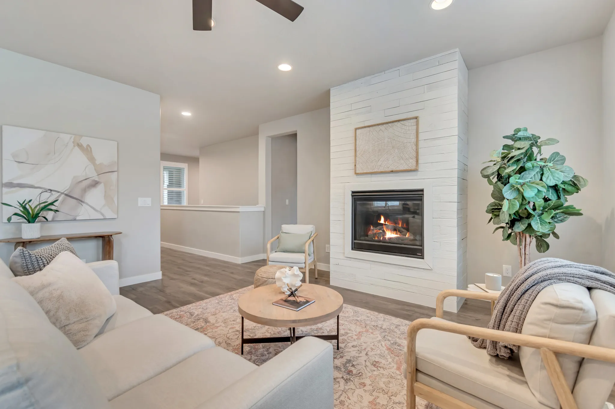Living area featuring a floor-to-ceiling white shiplap fireplace with a black firebox
