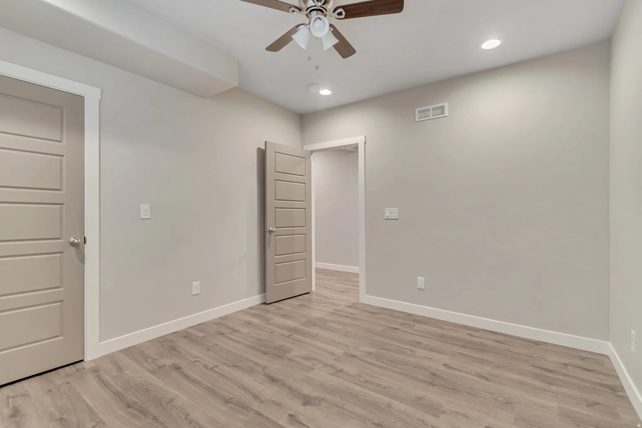 Room featuring wood-finish flooring, light gray walls, a ceiling fan, and recessed lighting