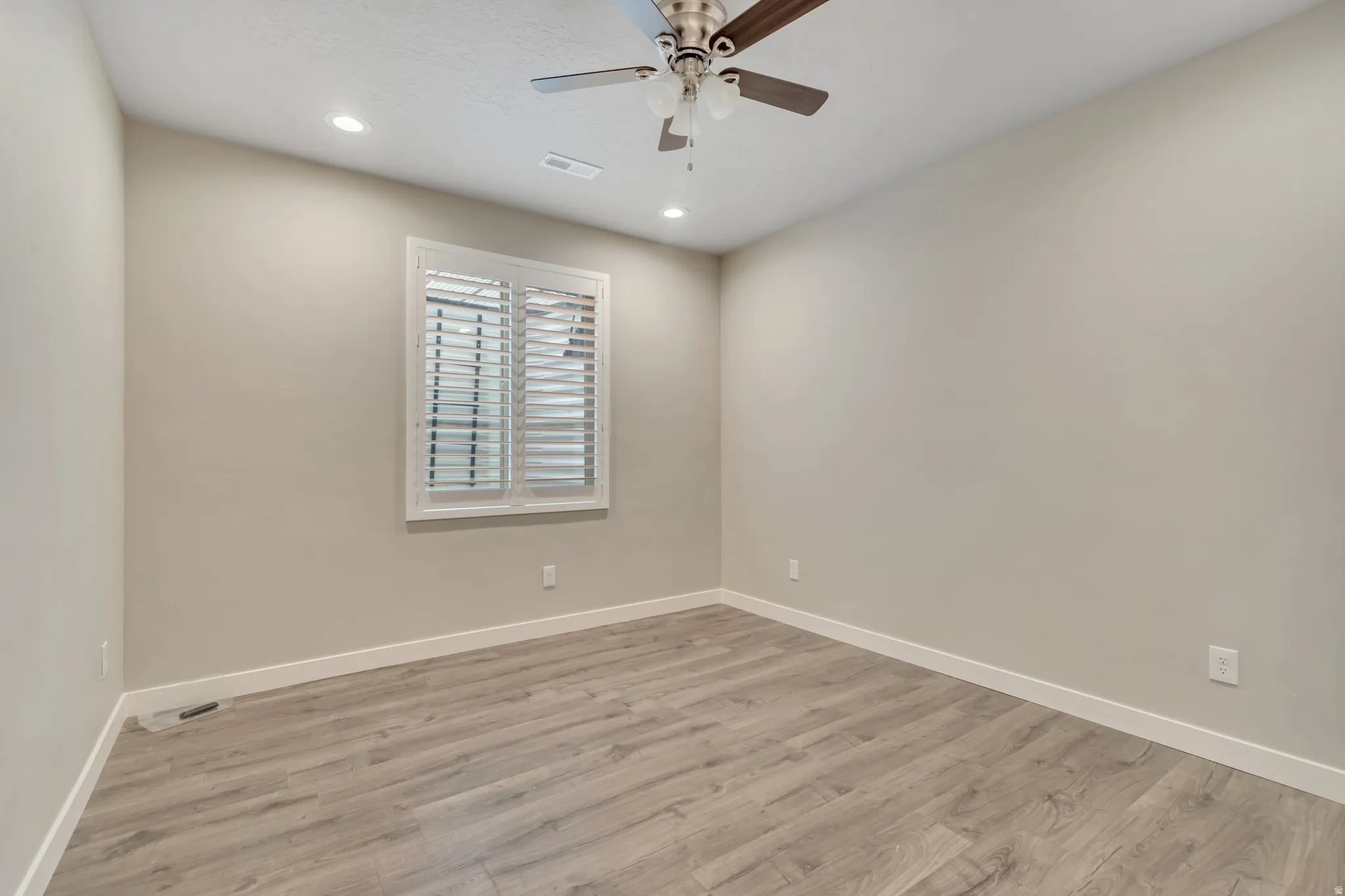 Interior room featuring wood-finish flooring, neutral wall paint, and white baseboards