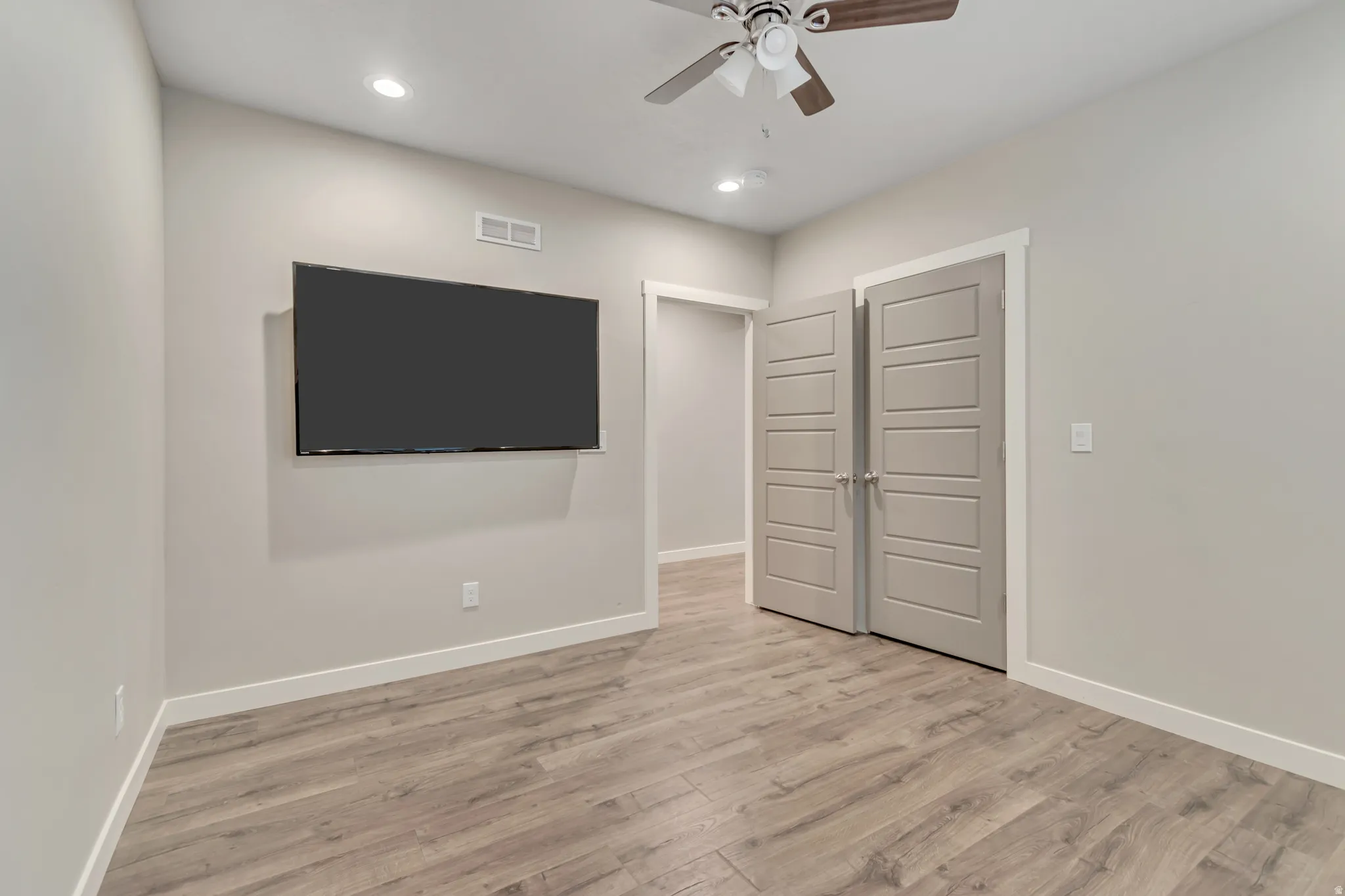 Room featuring wood-finish flooring, recessed lighting, and a ceiling fan