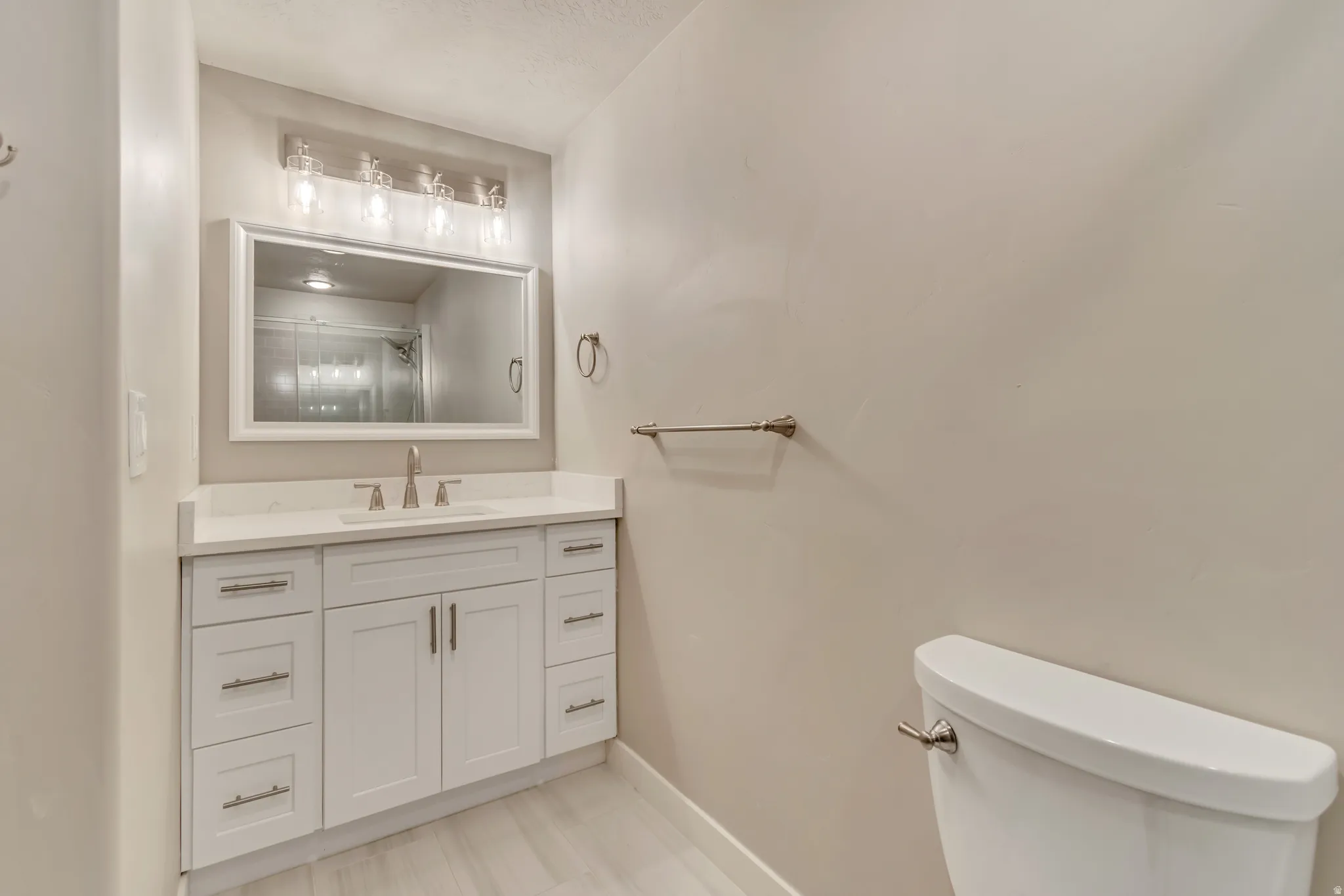 Contemporary bathroom featuring a white vanity with brushed nickel hardware, a rectangular undermount sink, and a countertop