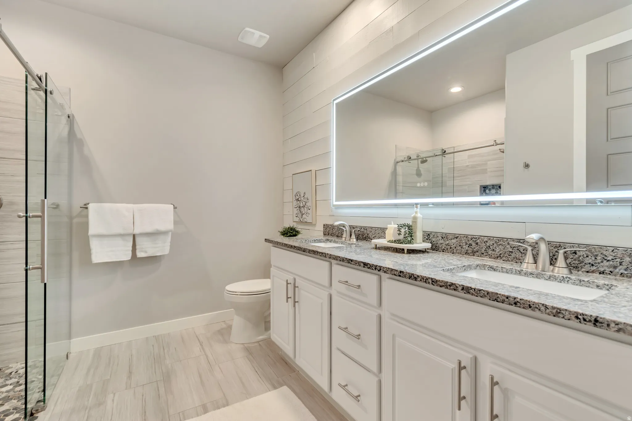 Dual vanity with granite countertops, undermount sinks, and brushed nickel fixtures
