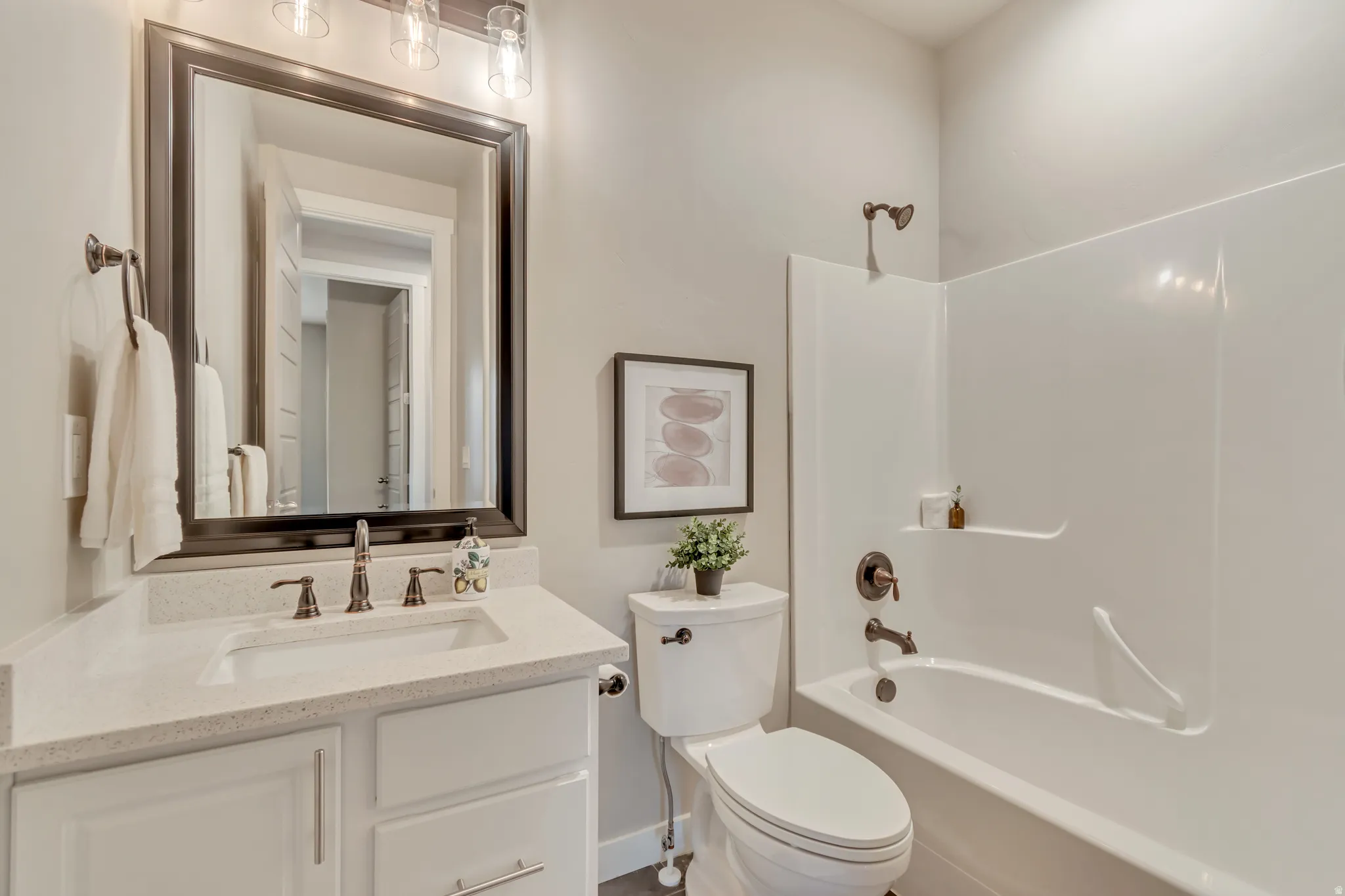 Bathroom featuring a white vanity with a light-toned countertop, an undermount sink, and a framed mirror