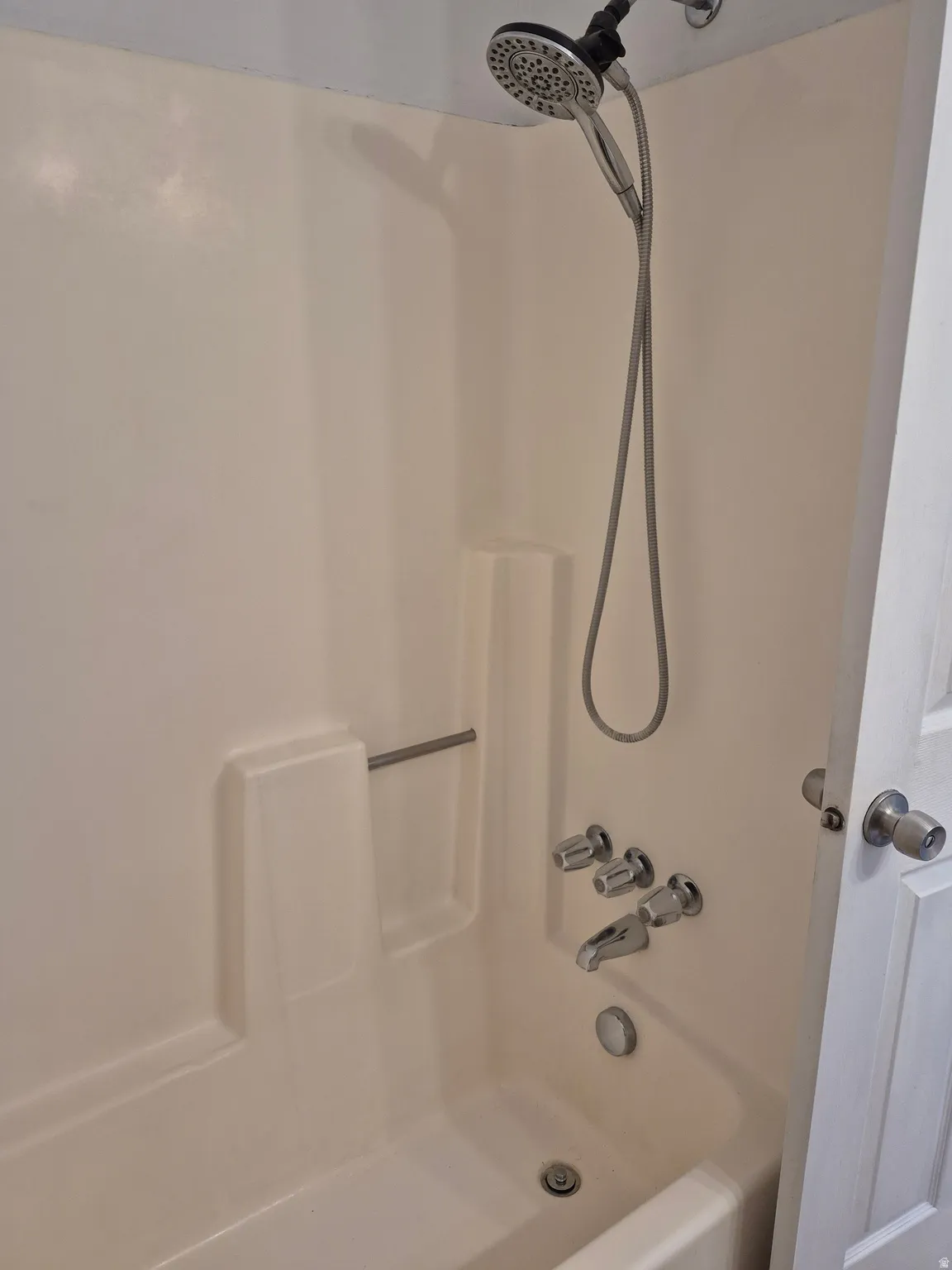 Bathtub/shower combination featuring a multi-function showerhead, integrated soap dish, and chrome fixtures