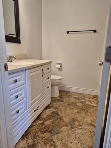 White vanity with integrated sink, brushed nickel faucet, and a light-toned countertop