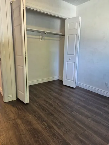 Spacious closet featuring bi-fold doors, hanging rod, and upper shelf