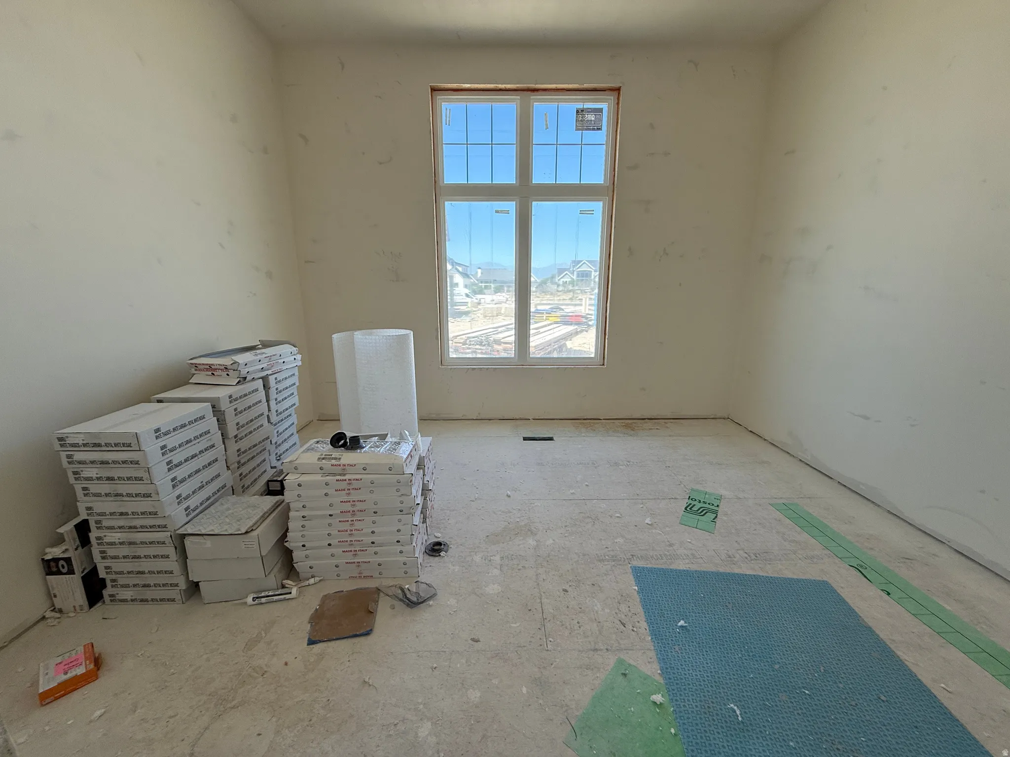 Room featuring a multi-pane window, unpainted walls, and unfinished flooring