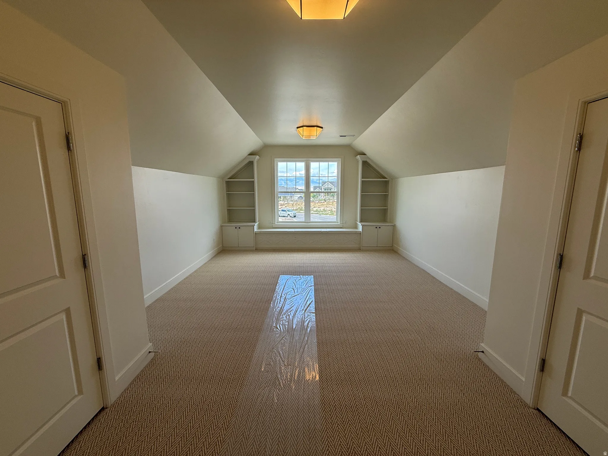 Recessed window with built-in shelving and cabinetry, recessed ceiling light fixture, and textured carpet flooring