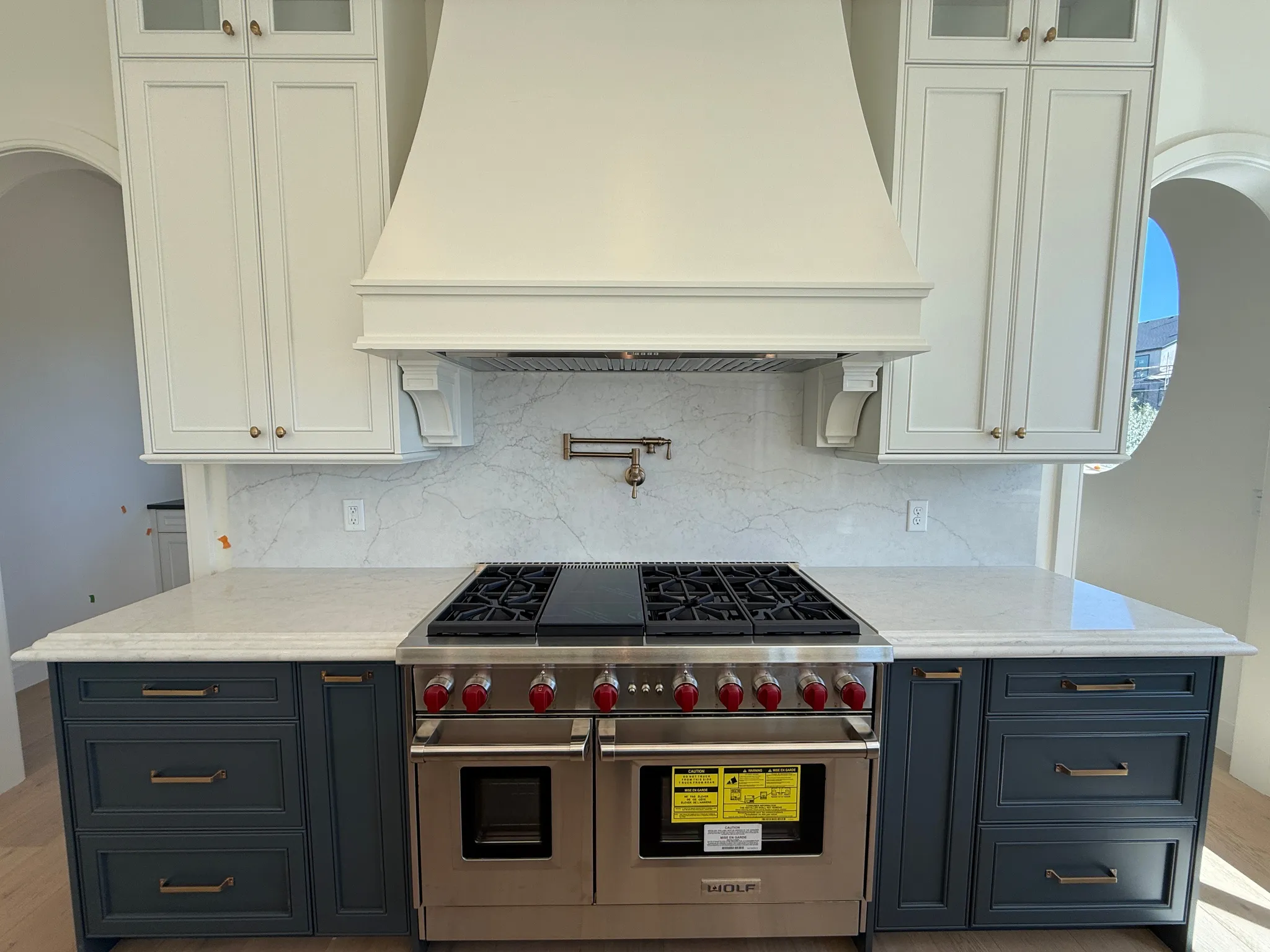 Professional-grade stainless steel range with a pot filler, set against a stone slab backsplash