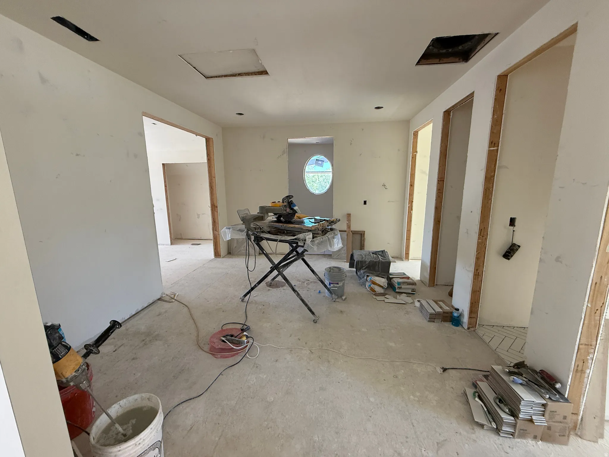 Interior space under renovation, featuring rough-in doorways and an oval window